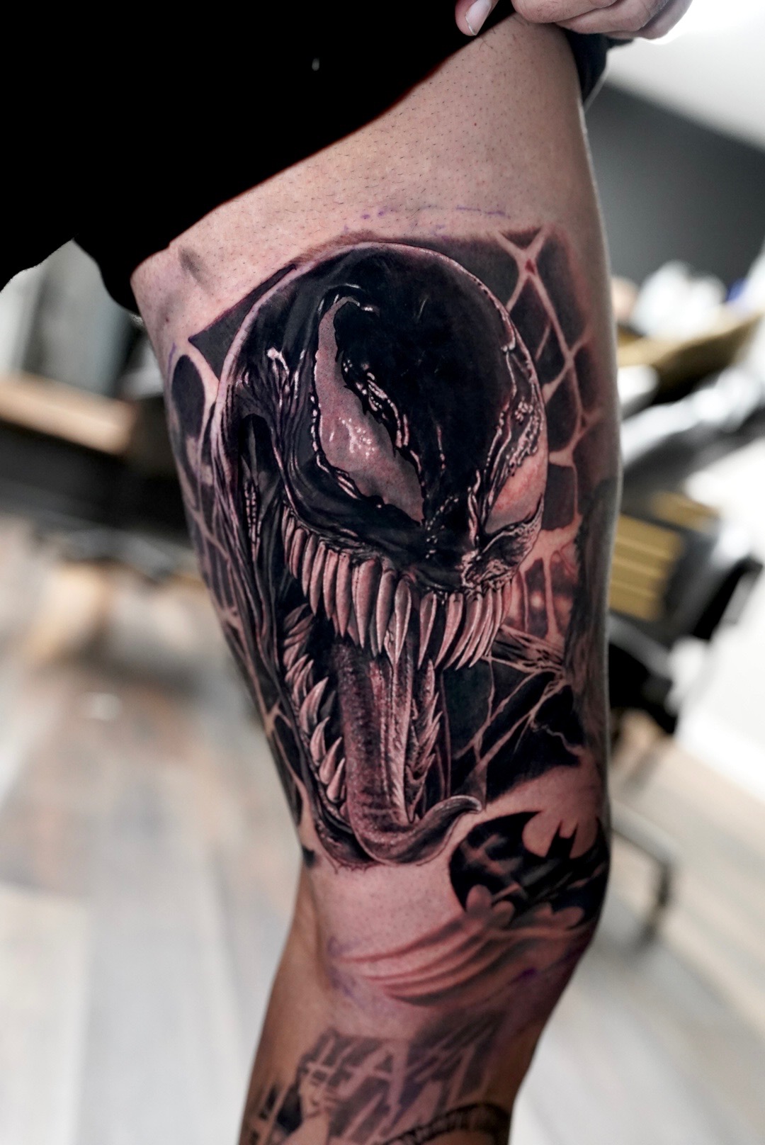 Black and grey Venom thigh tattoo by Ben Crooks